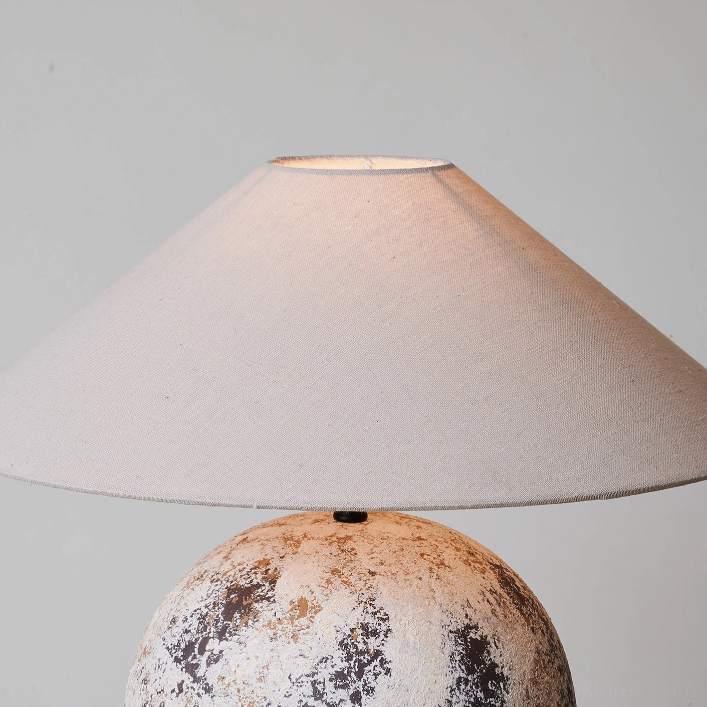 Close-up front view of Surya table lamp upper section - fabric lampshade and metal connector detail on grey background