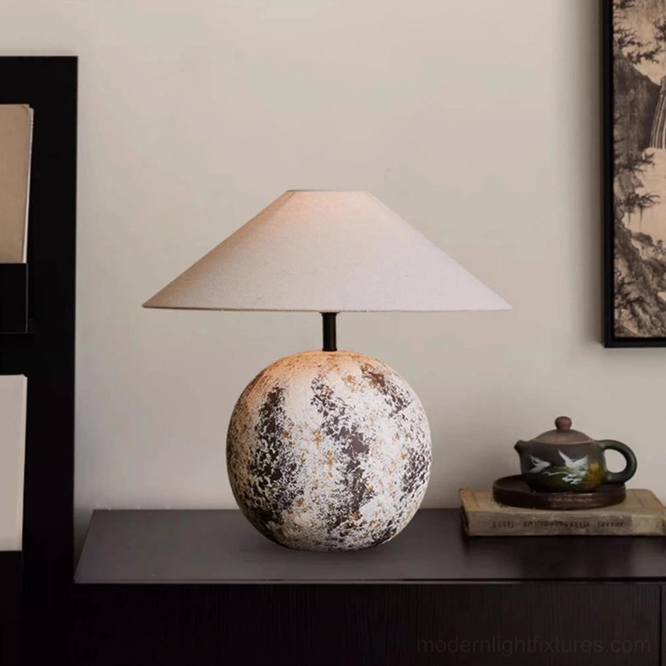 Surya sculptural table lamp side profile positioned on dark wood console table in minimalist home interior setting