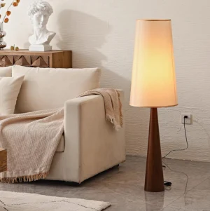 Svelte tapered floor lamp illuminated in modern living room with beige sofa, warm ambient lighting