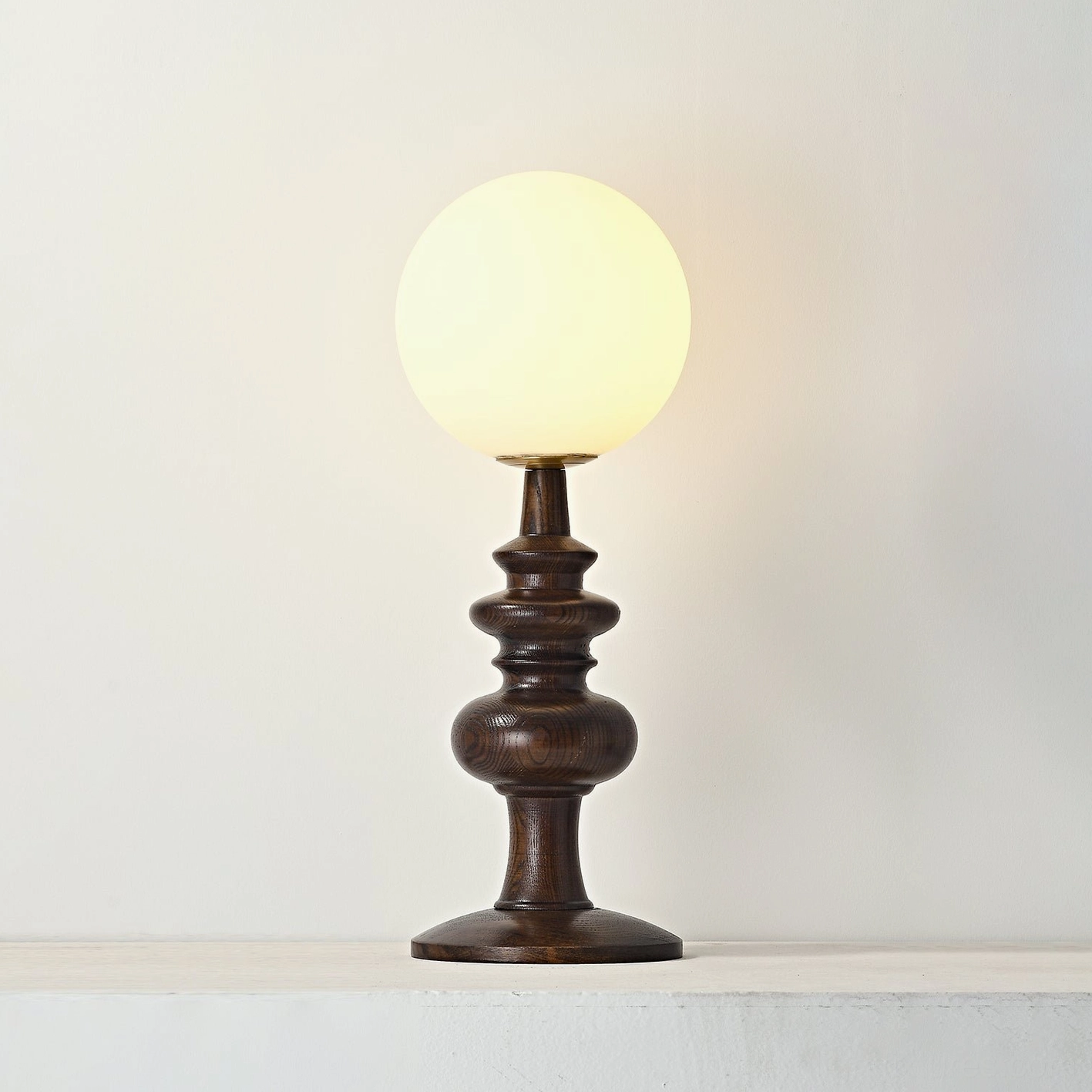 Retro rustic minimalist Sveta globe table lamp on beige tabletop - traditional turned wood design