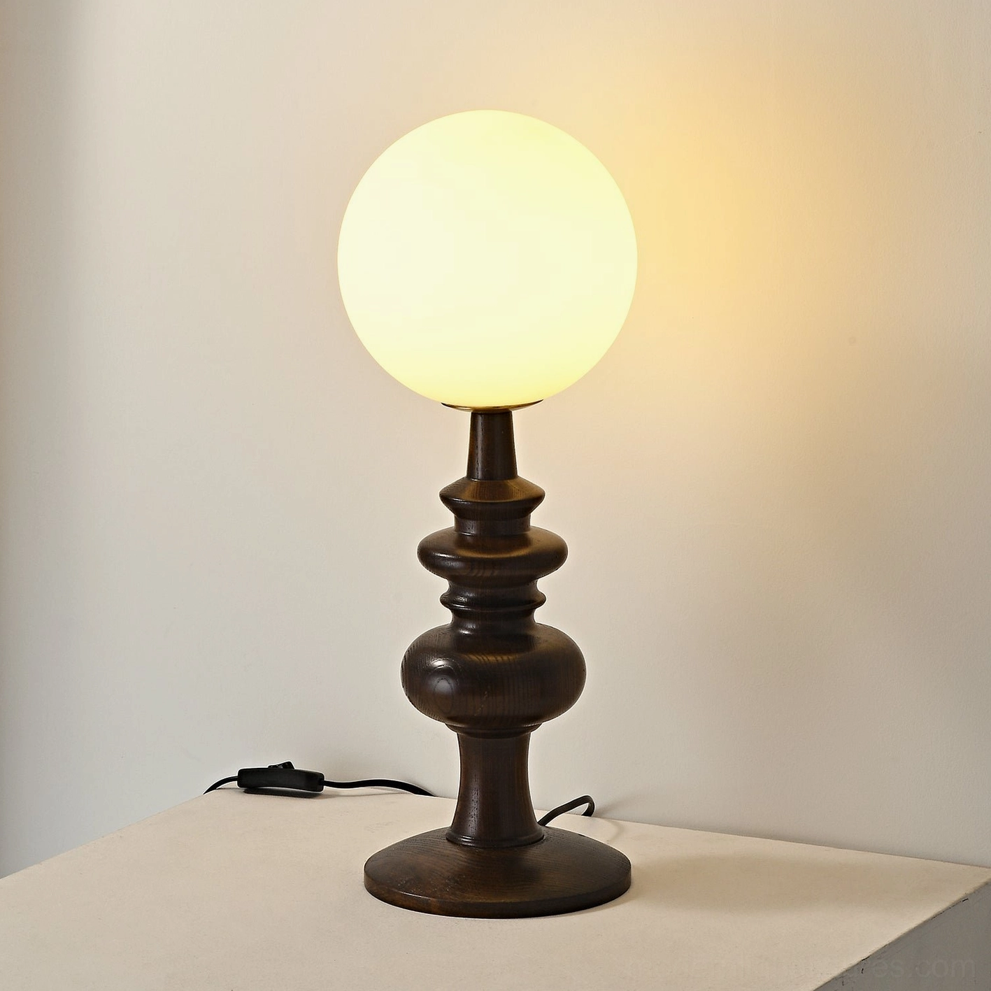 Classic Sveta table lamp with turned wood decorative stand and power cord on wood surface