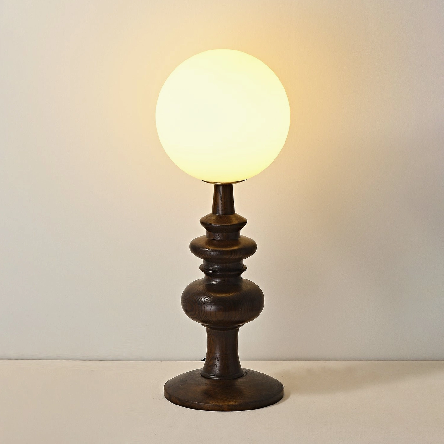 Vintage-inspired Sveta globe table lamp with dark wood base casting warm ambient light
