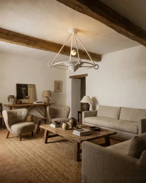 Matte white Swanelle chandelier installed in rustic farmhouse living room with exposed wooden ceiling beam and warm neutral decor, contemporary lighting fixture