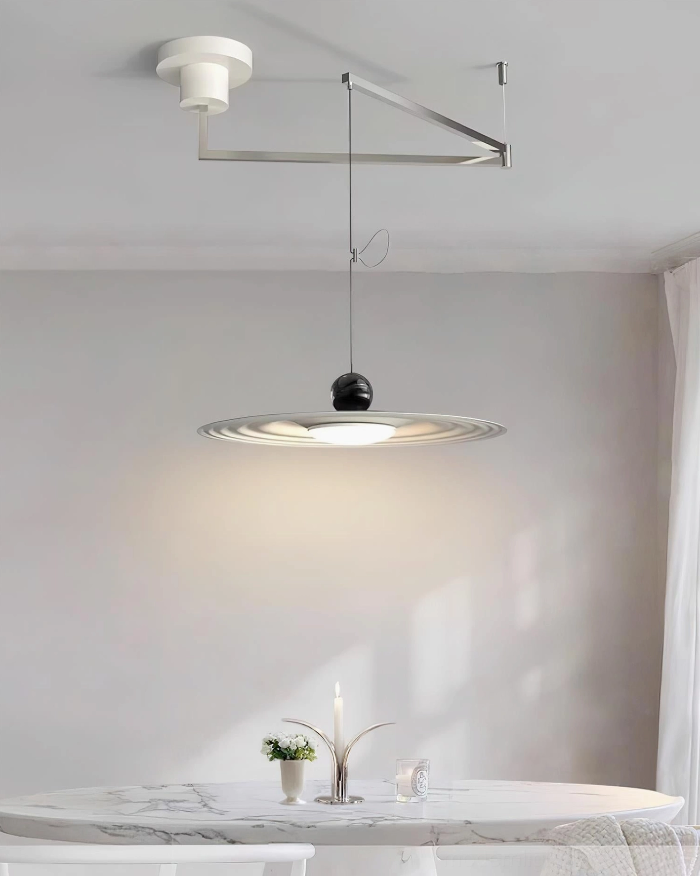 Swing arm pendant lamp showing adjustable height and directional lighting capability in contemporary space