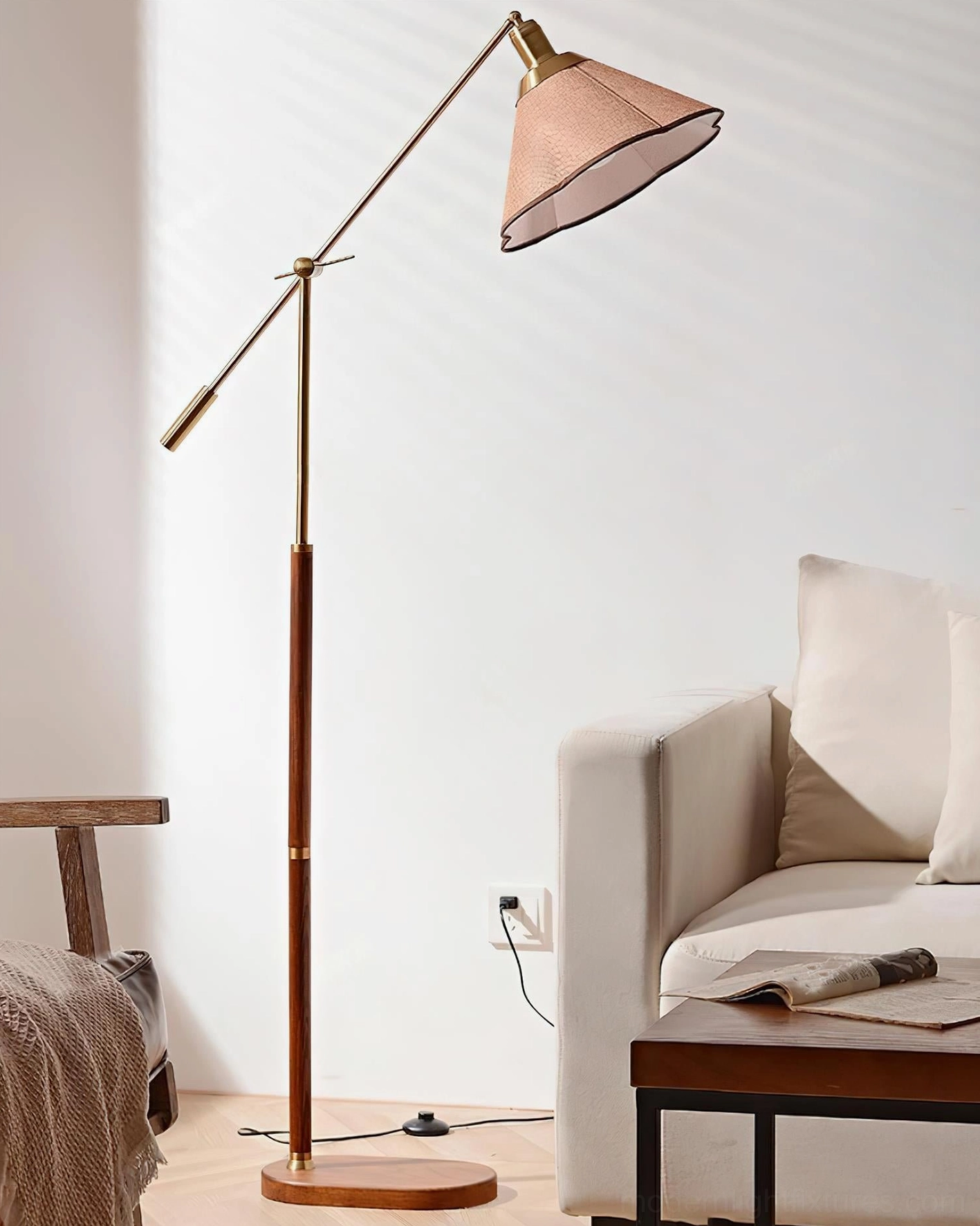 Low-angle side view of swing arm floor lamp highlighting walnut wood construction, round base, and brass hardware details