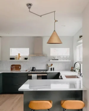 Adjustable swing arm pendant light installed above modern kitchen island with dining area