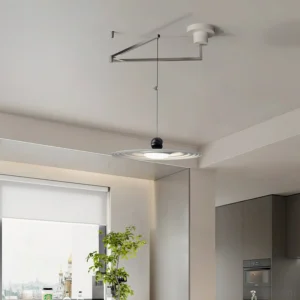 Adjustable pendant light installed over kitchen island in minimalist modern dining space with neutral warm interior