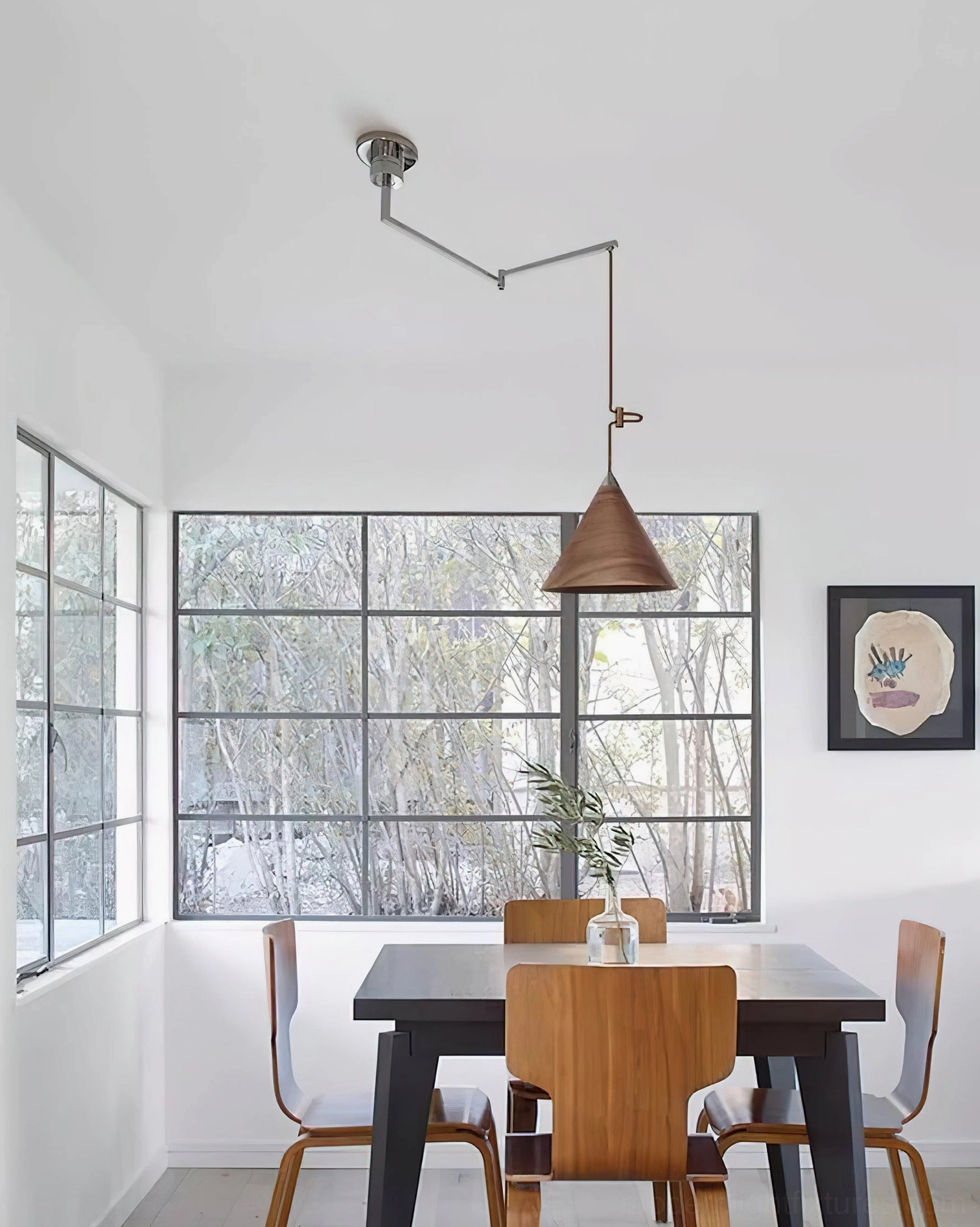 Scandinavian minimalist swing arm pendant light in bright dining space with industrial windows