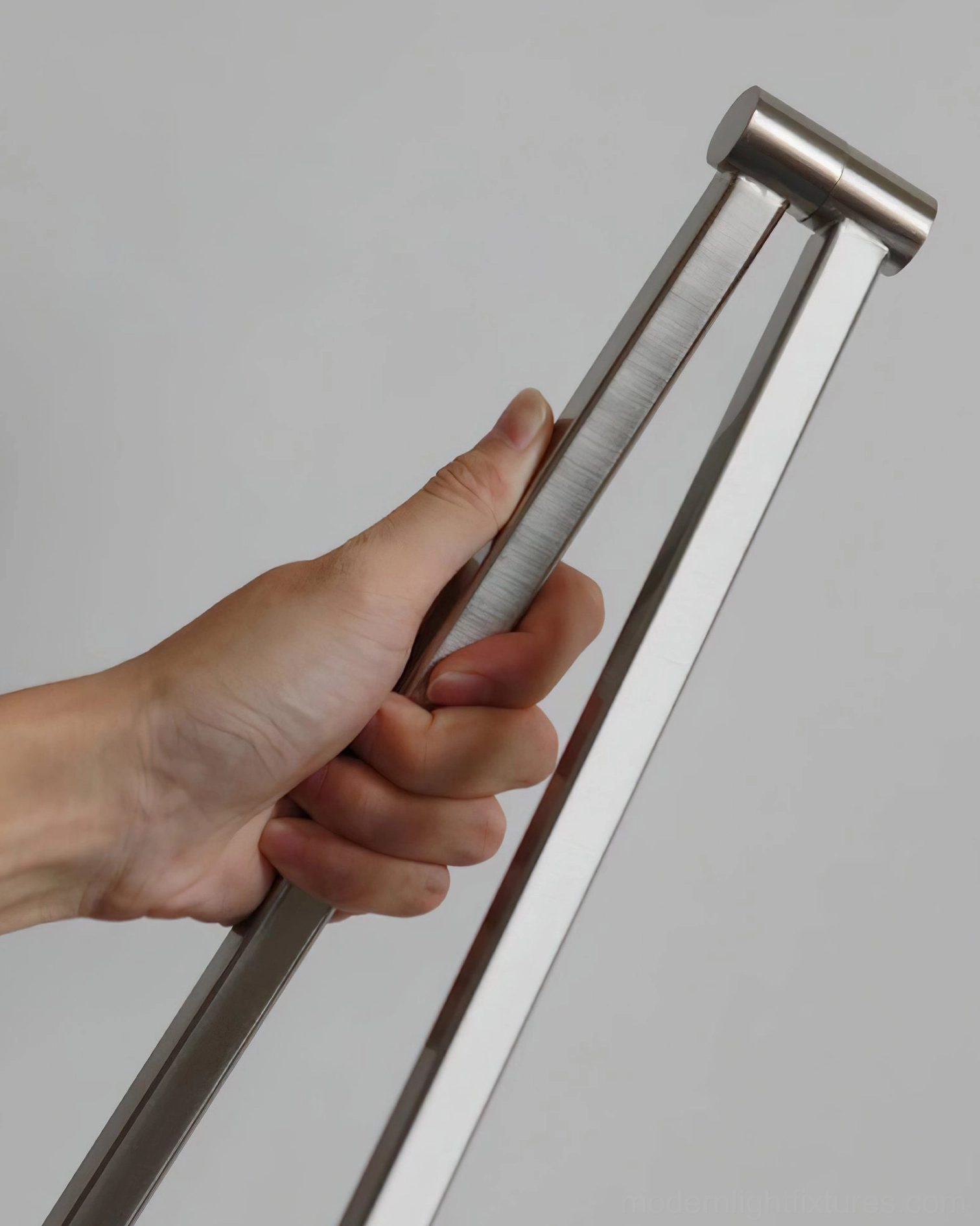 Close-up of brushed nickel metal swing arm joint and hardware detail