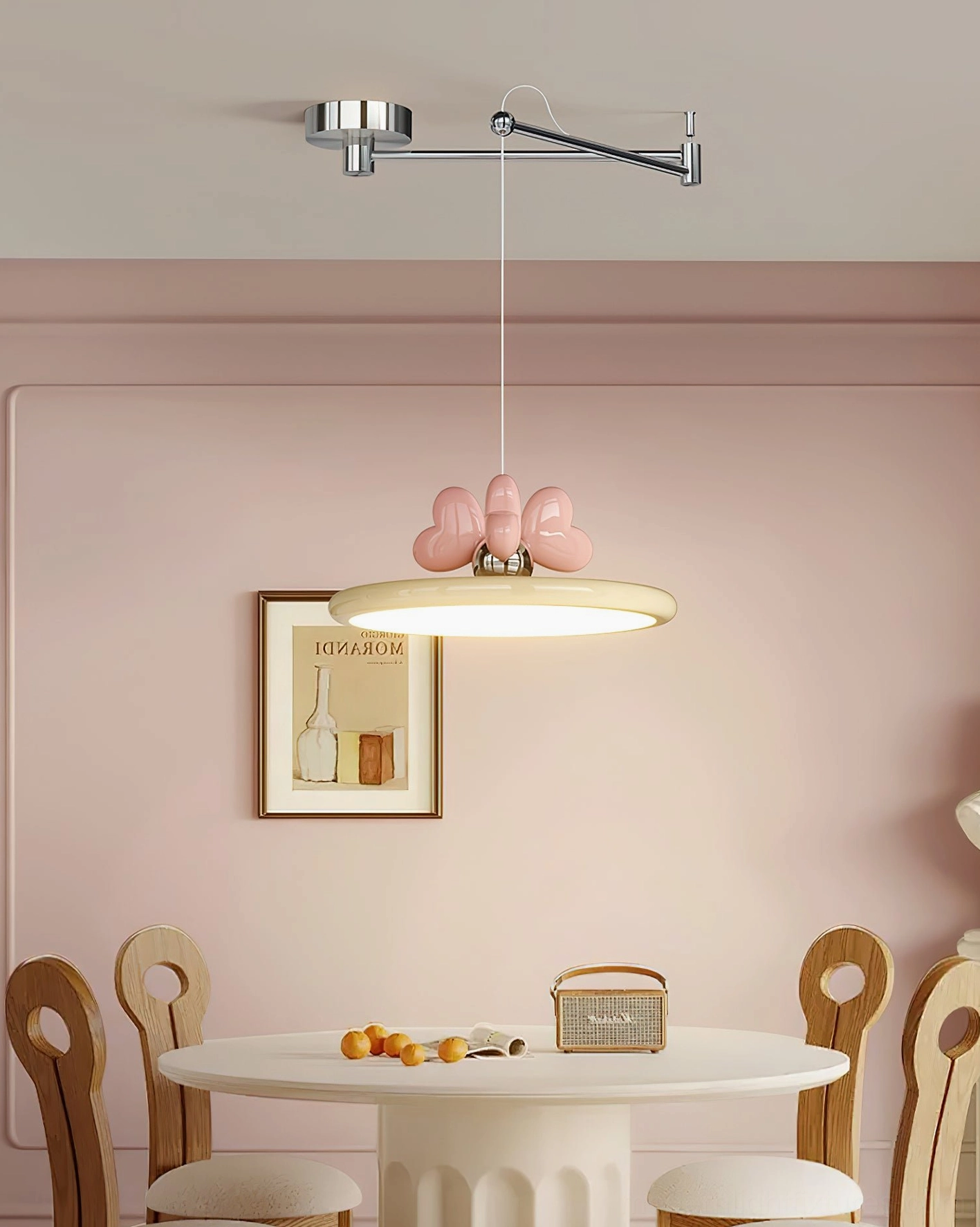 Cozy dining area with swing arm pendant lamp coordinating with pink accent wall and framed artwork