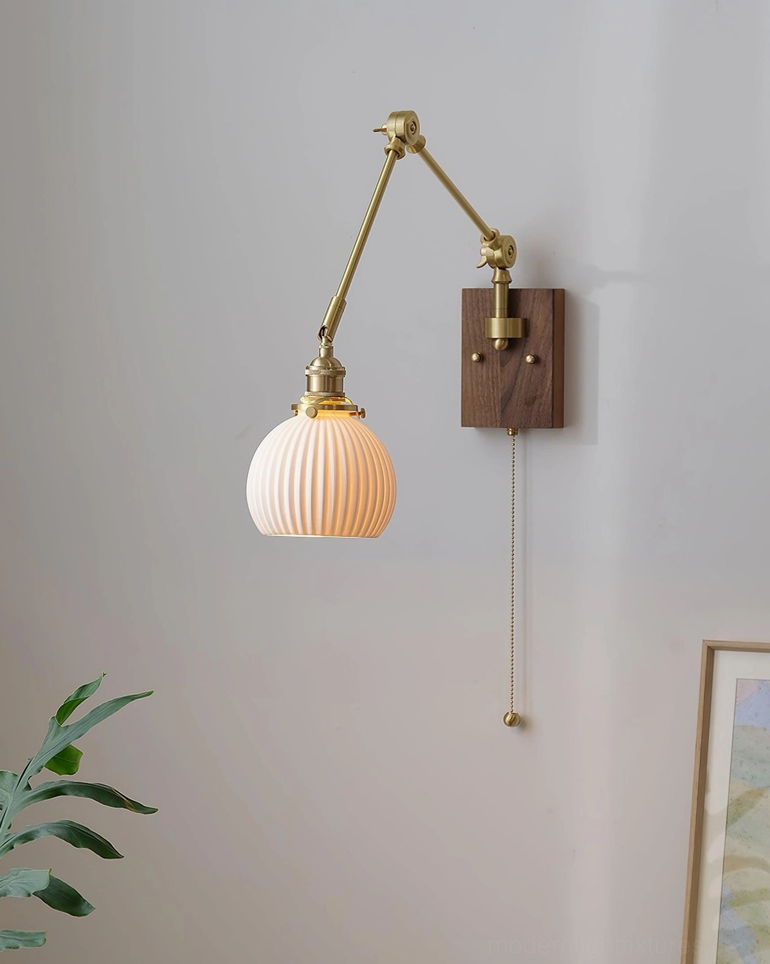 Swing arm sconce mounted in modern minimalist bedroom beside nightstand and table lamp