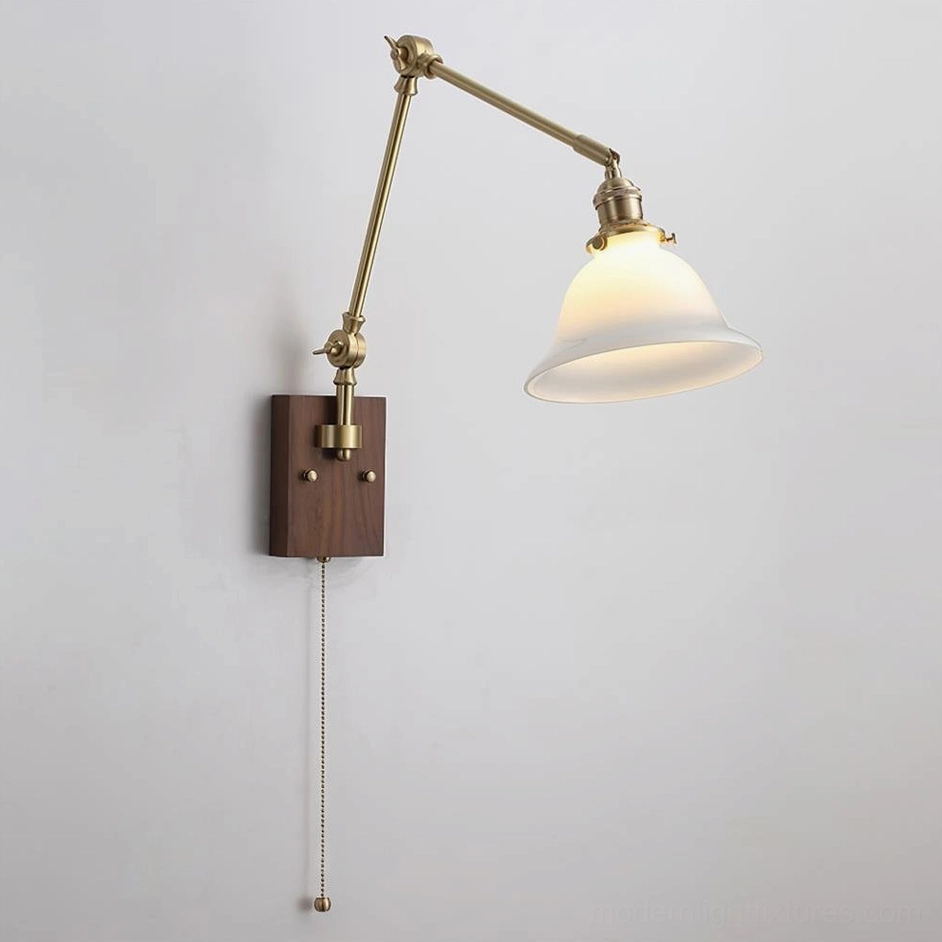 Swing arm wall light in white color variant featuring white glass dome, brass metal arms, and walnut wood backplate, vintage sconce design