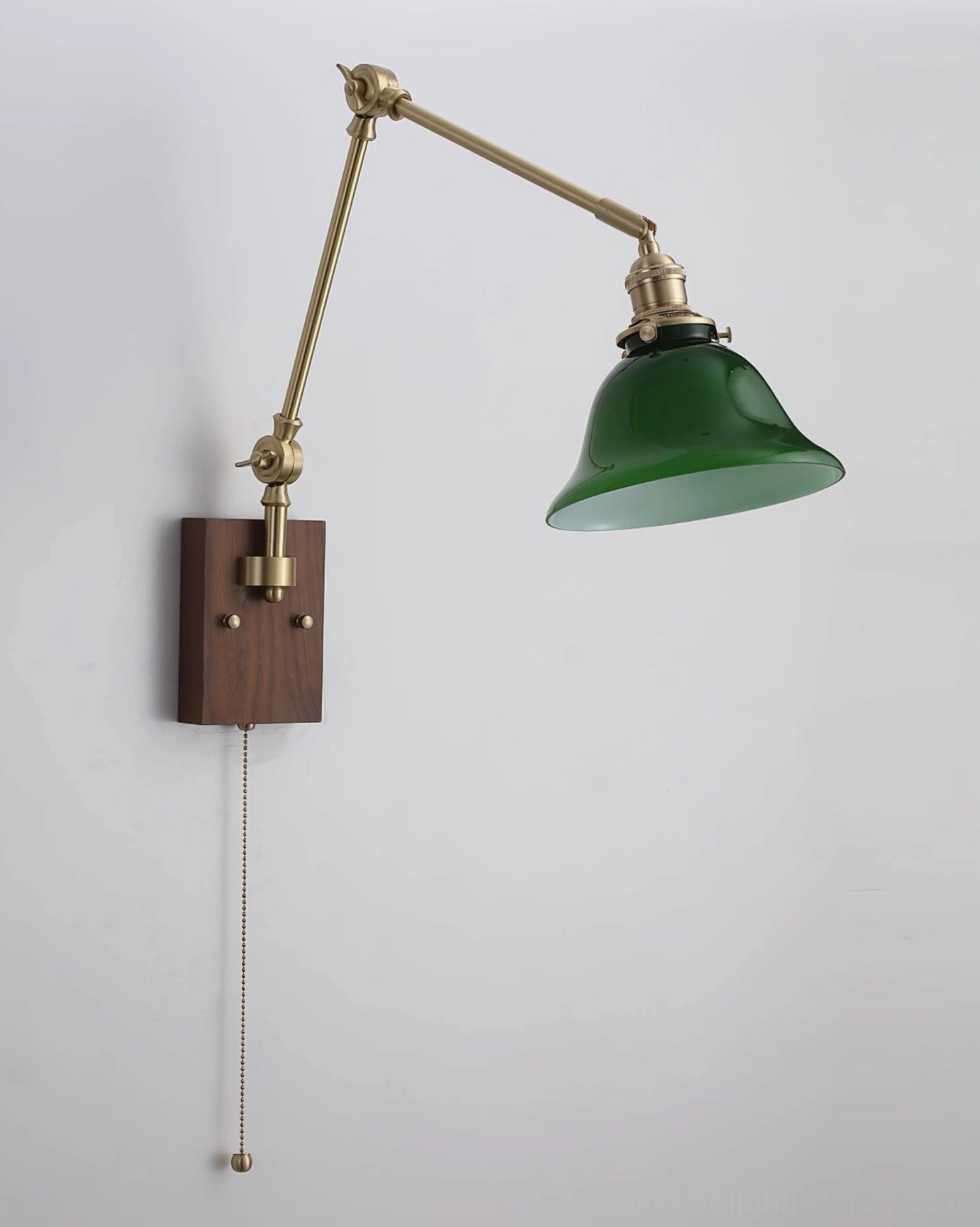 Reverse angle installation of swing arm wall sconce showing green glass shade on left, brass metal hardware and dark wood backplate
