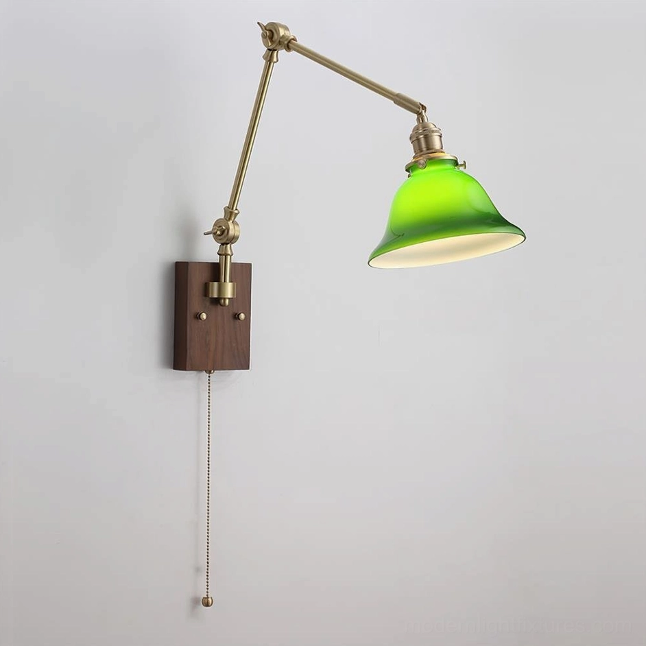 Swing arm wall sconce showing color combination of walnut wood base with brass hardware and green glass dome shade, product variant display