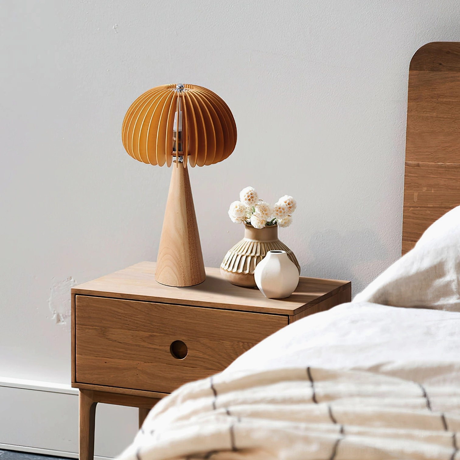 Sylora wooden table lamp on bedroom nightstand, warm master bedroom setting with wooden furniture and neutral bedding