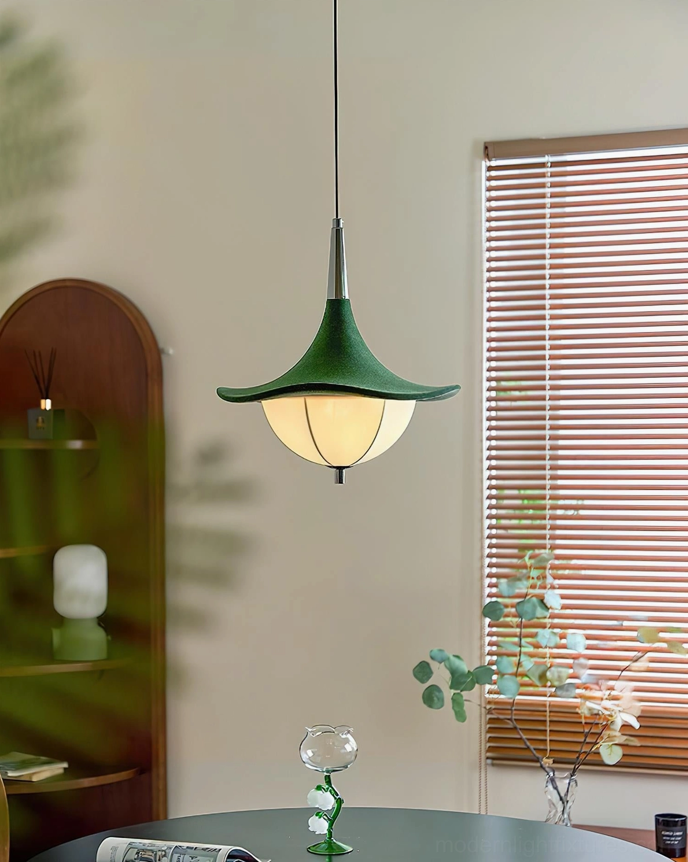 Illuminated Sylva Drift pendant light in home dining space with wooden arched shelf and botanical decor