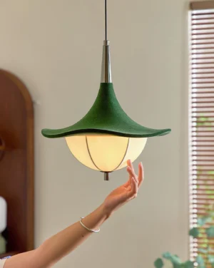 Organic leaf-shaped pendant lamp illuminated in minimalist home interior with wooden furniture and window light