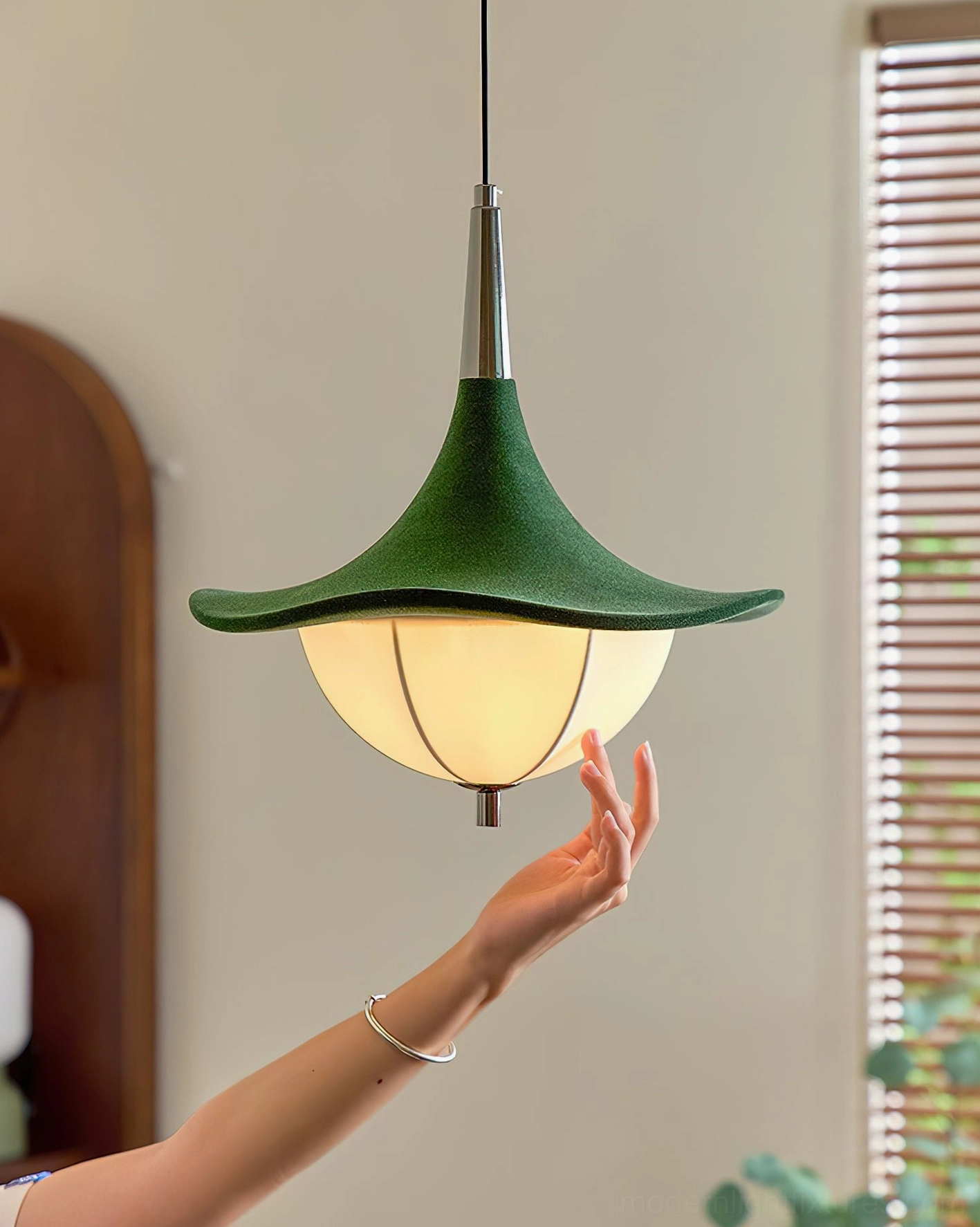 Organic leaf-shaped pendant lamp illuminated in minimalist home interior with wooden furniture and window light