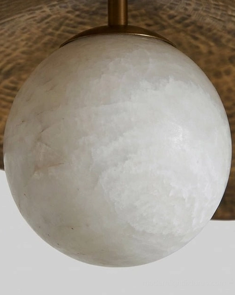 Close-up detail of Sylvune's hammered brass leaf shade texture and natural alabaster stone veining