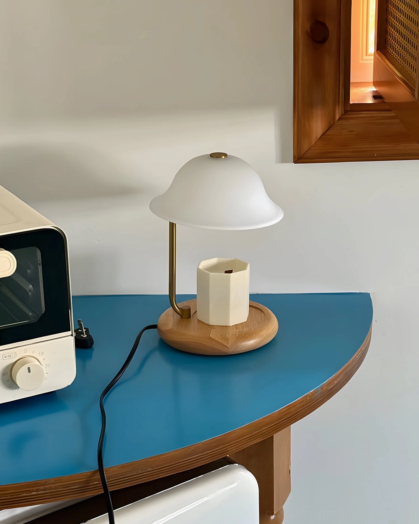 Modern candle warmer lamp with matte white shade and brass accents in kitchen side table setting