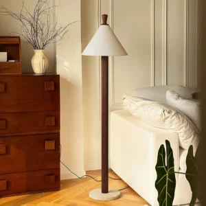Takumi modern floor lamp with dark walnut pole and travertine stone base in bedroom interior design setting