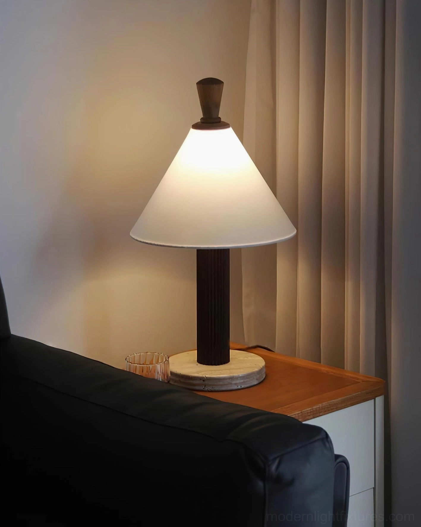 Takumi table lamp close-up view with dark fluted wood pole, leather sofa styling, and minimalist design