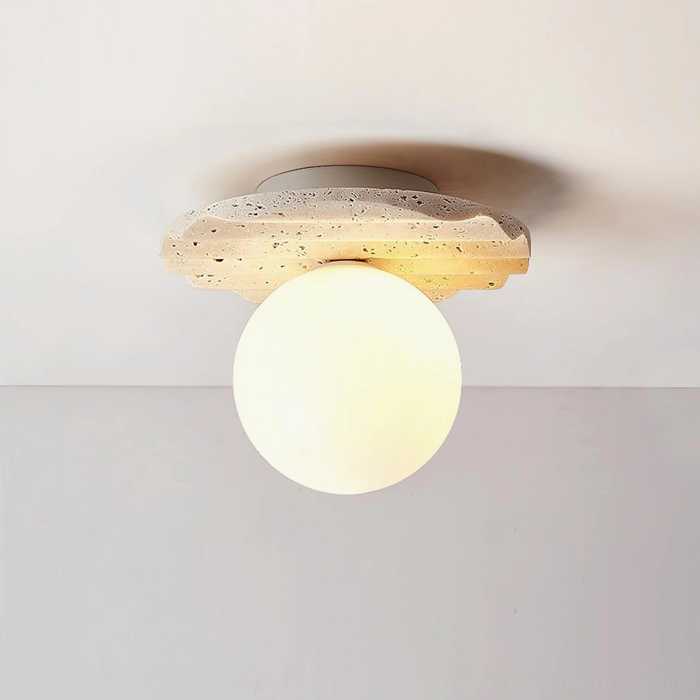 Illuminated Talia modern flush mount ceiling lamp with wavy travertine base and frosted glass shade, close-up frontal view