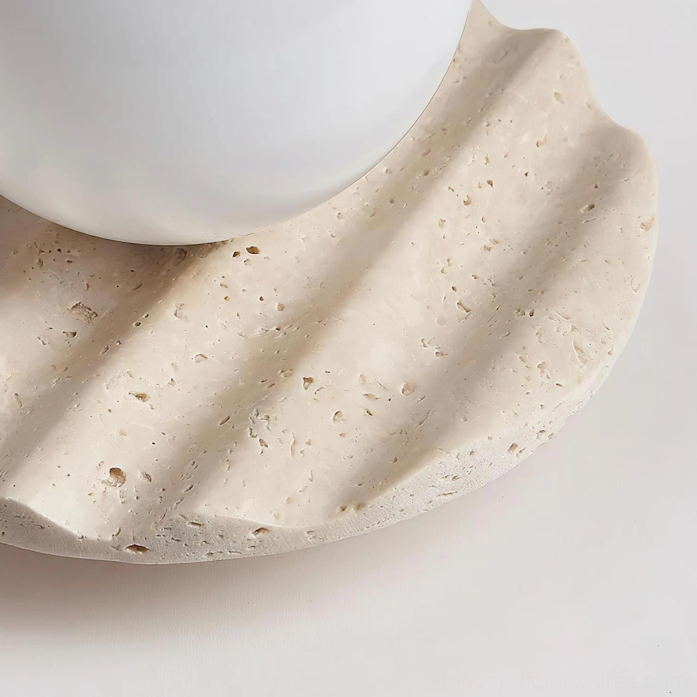 Talia modern ceiling light fixture displaying organic travertine stone base with natural pores and frosted glass sphere