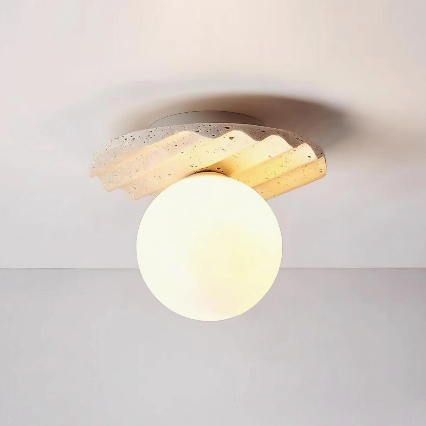 Talia modern ceiling light with ribbed travertine stone base and spherical frosted glass diffuser, studio shot