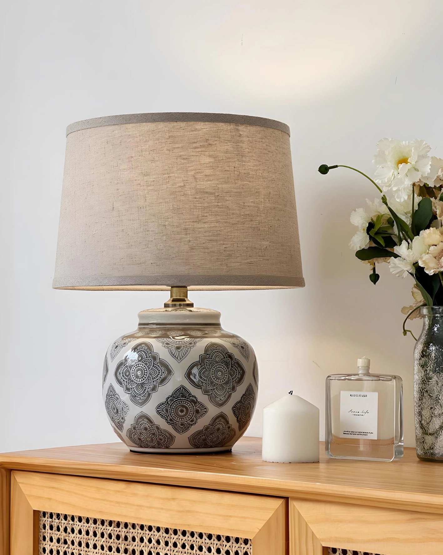 Designer ceramic table lamp on wooden dresser with perfume bottles and candle decor