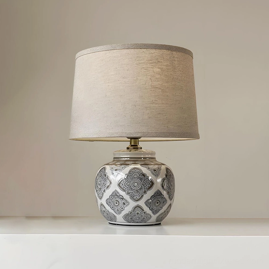 Talora ceramic table lamp complete product shot with geometric patterned base and beige drum shade all plug options