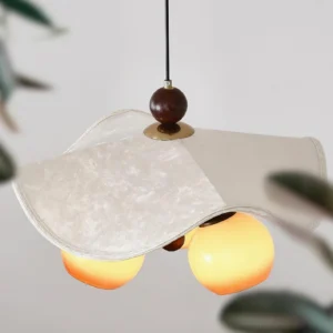 Close-up detail of Talvera pendant lamp cream fabric shade with brass hardware and glowing glass orbs