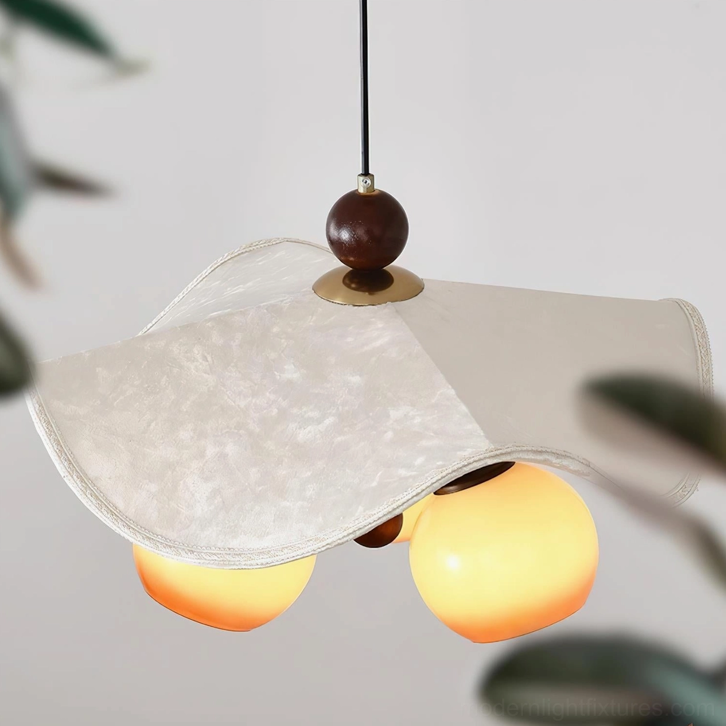 Close-up detail of Talvera pendant lamp cream fabric shade with brass hardware and glowing glass orbs