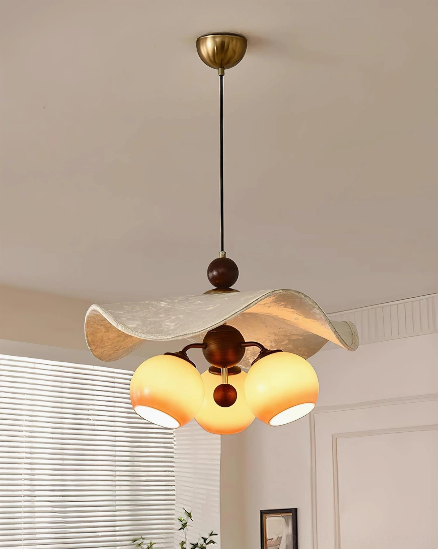 Talvera pendant light with mid-century modern styling and glowing glass bulbs near window blinds