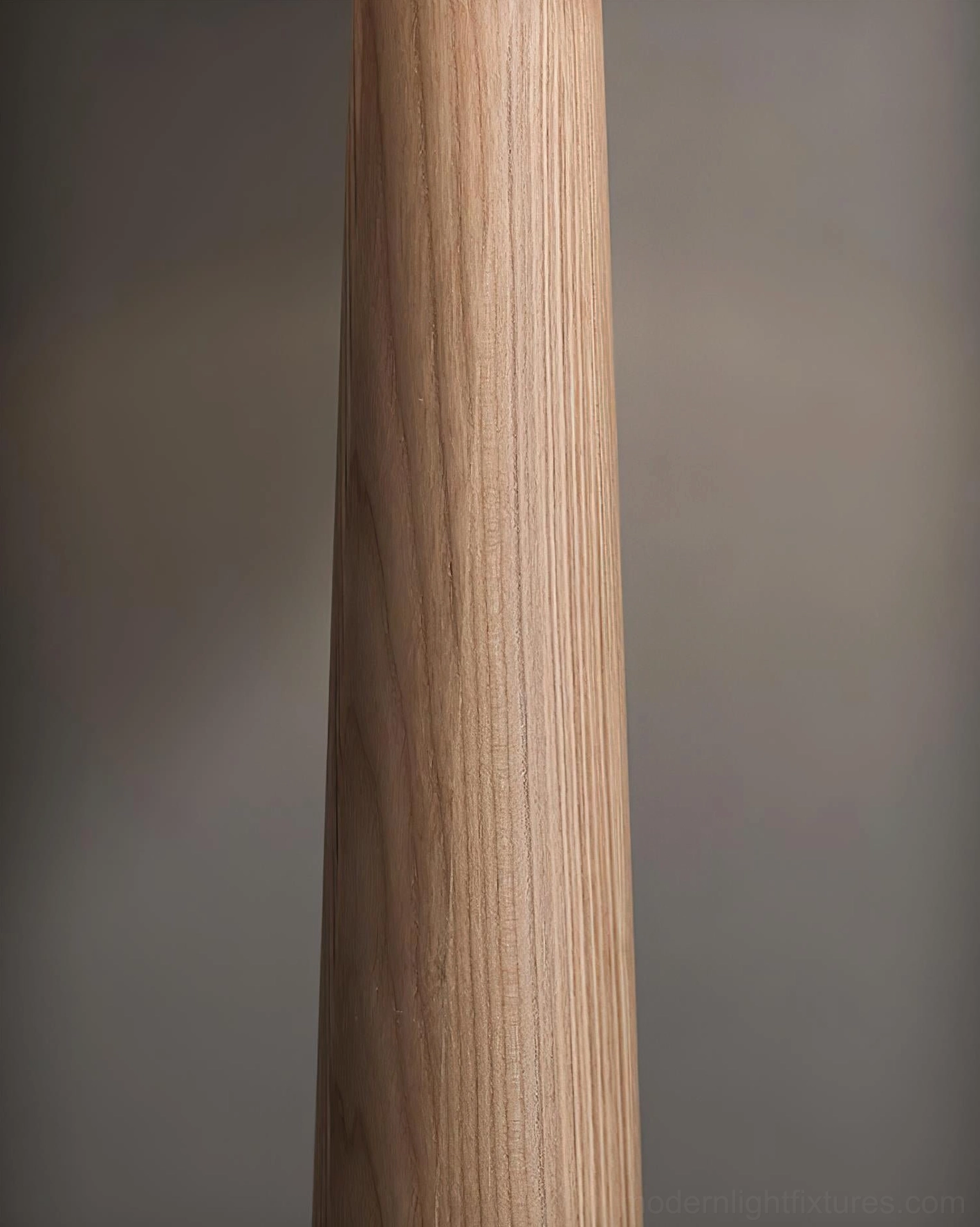 Modern tapered floor lamp showing black pole with marble and wood base and linen cone shade