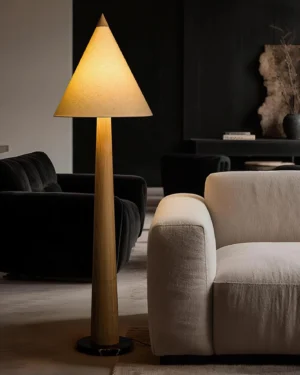 Tapered floor lamp in luxury modern living room with light wood pole and warm beige cone shade