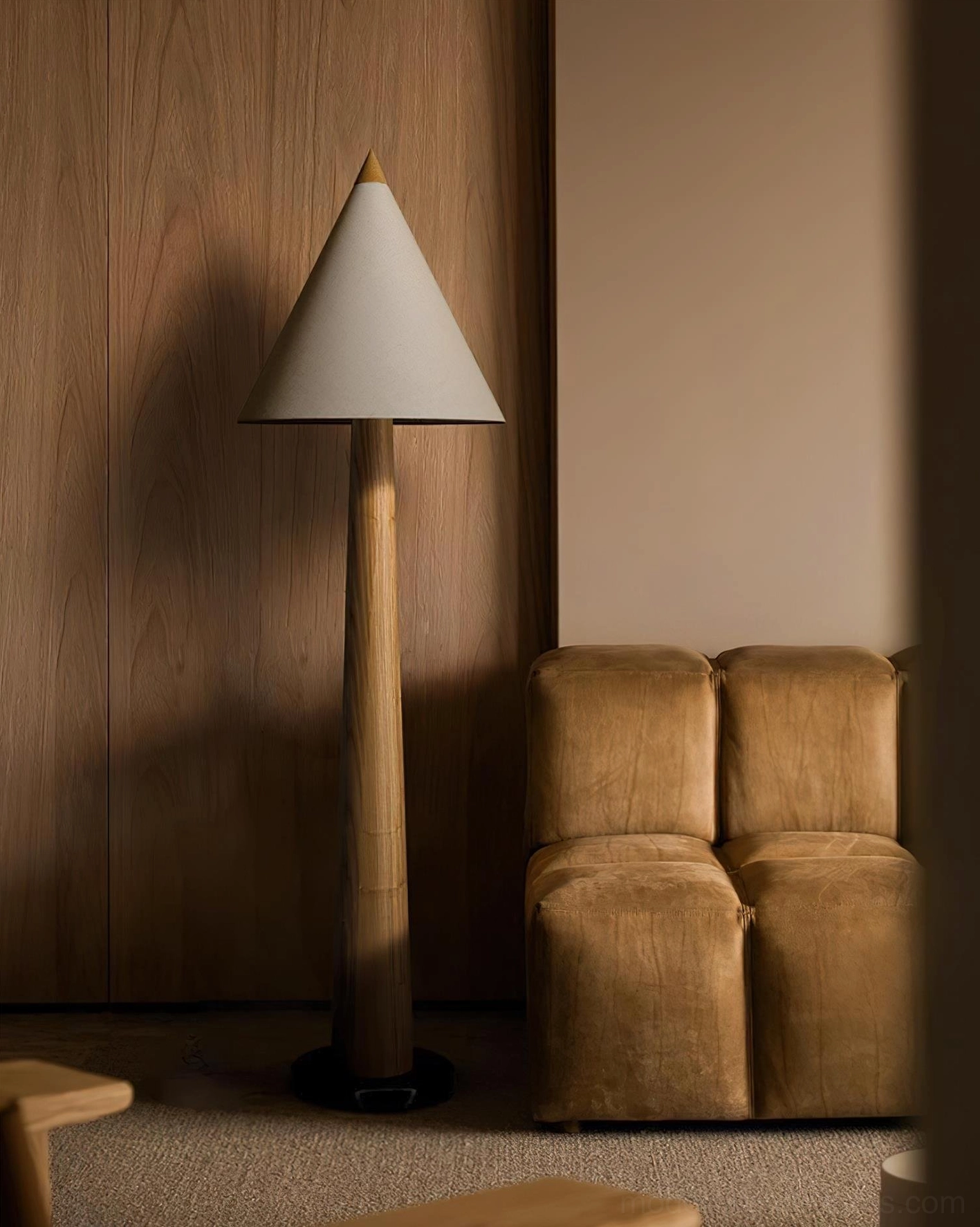 Contemporary tapered floor lamp with natural brown wooden pole and off-white linen shade in warm interior