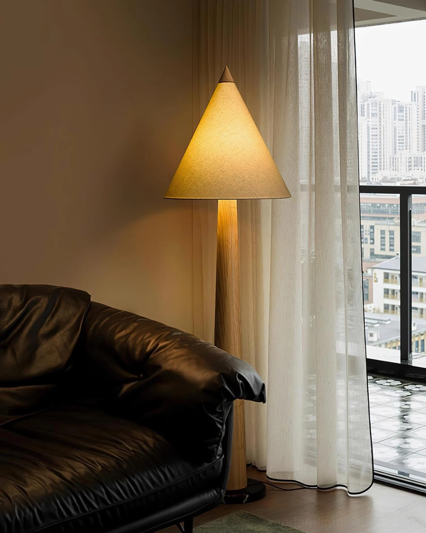 Minimalist tapered floor lamp with dark pole and yellow fabric cone shade in modern apartment setting