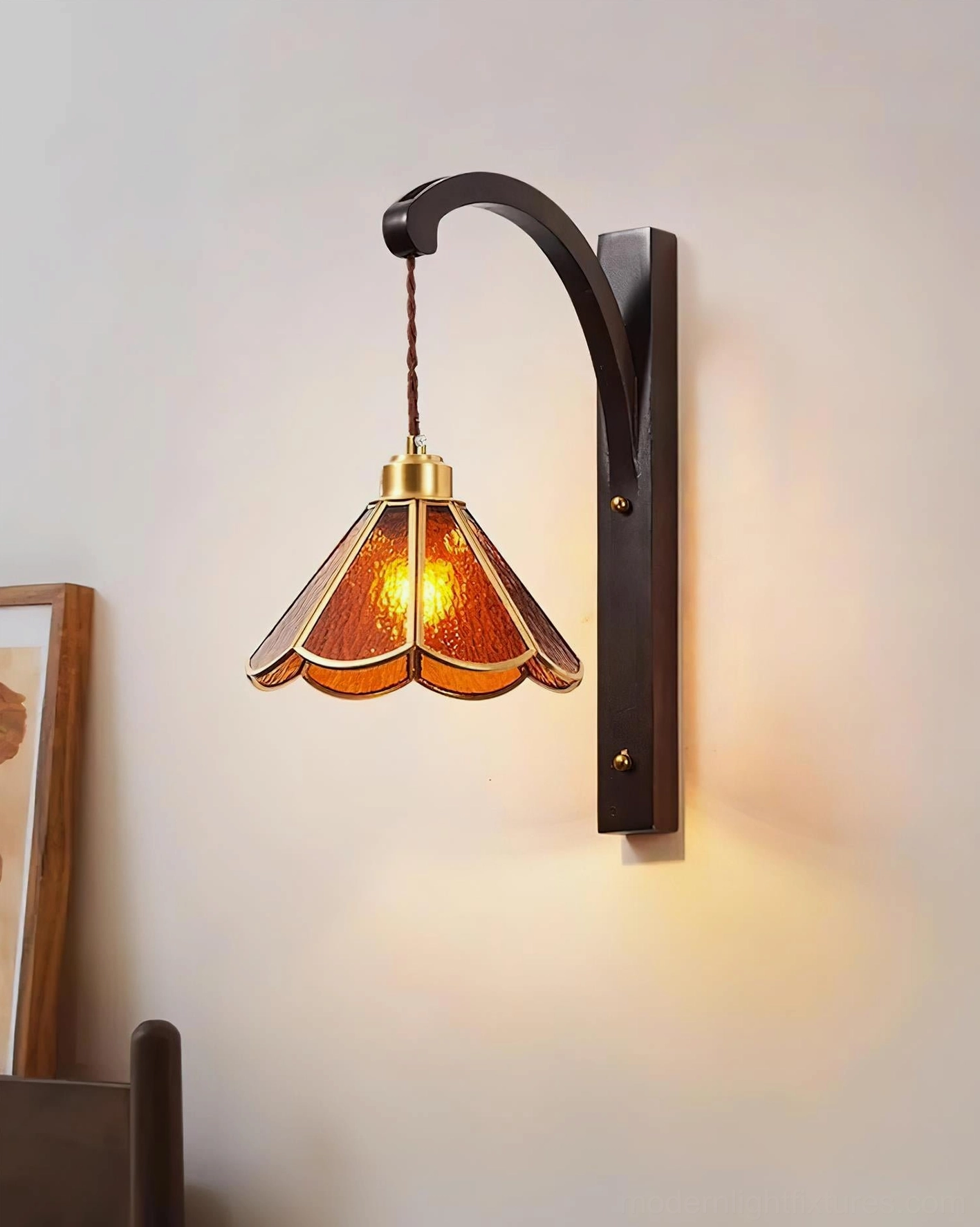Tavelle petal wall lamp side profile view showing curved bronze bracket and amber stained glass shade