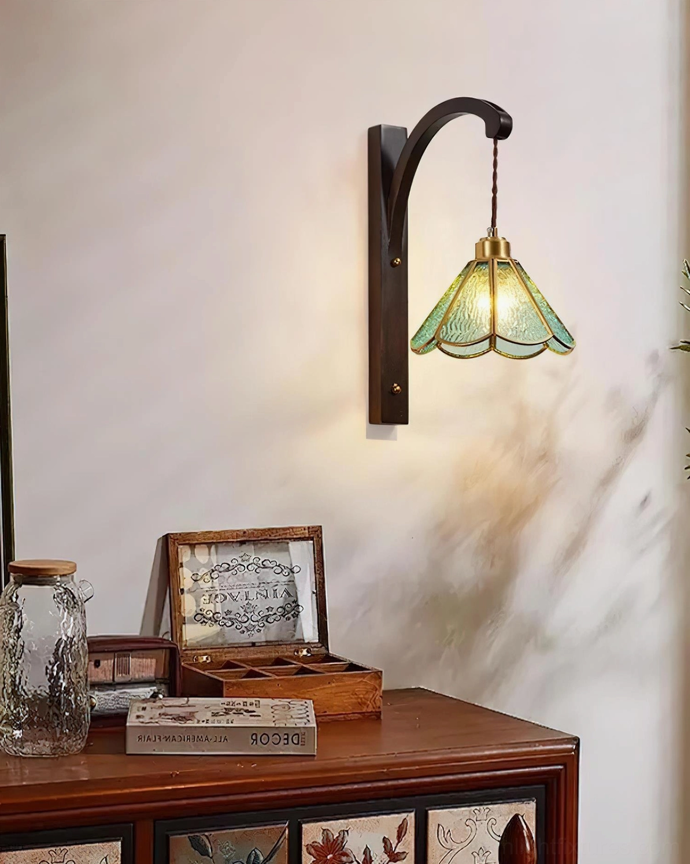 Tavelle petal wall sconce displayed on vintage dresser with dark bronze bracket and blue stained glass