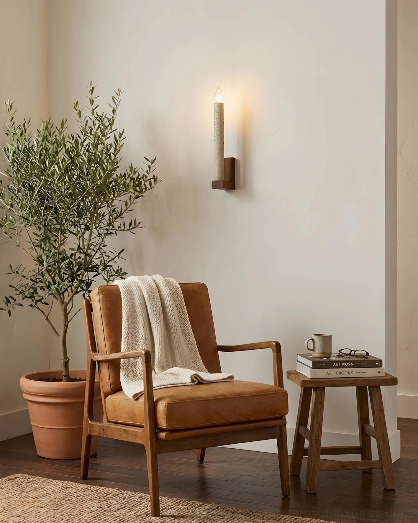 Tavero wall sconce mounted in cozy reading nook with leather armchair and wooden side table
