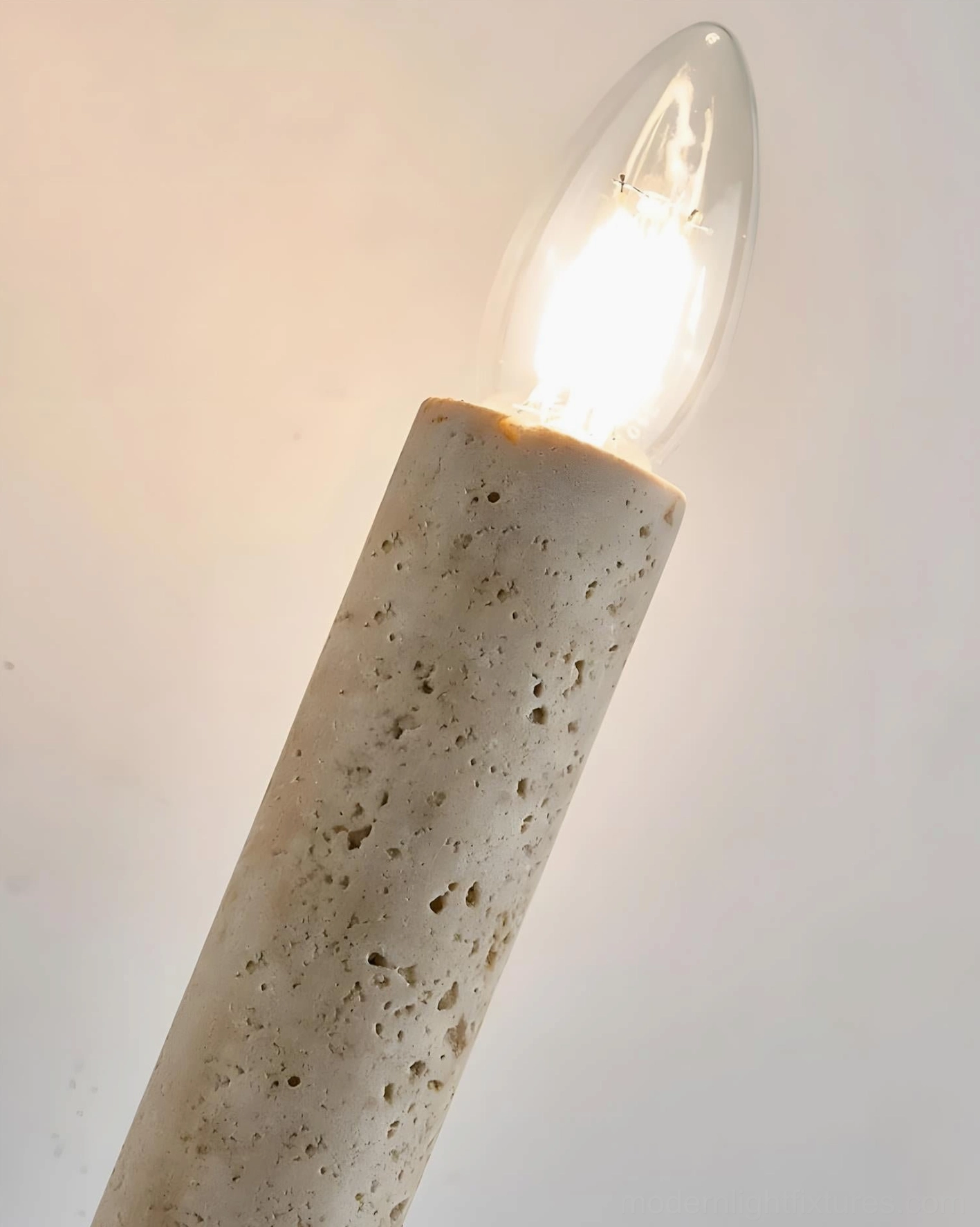 Tavero sconce installation view showing walnut backing and beige travertine stone composition