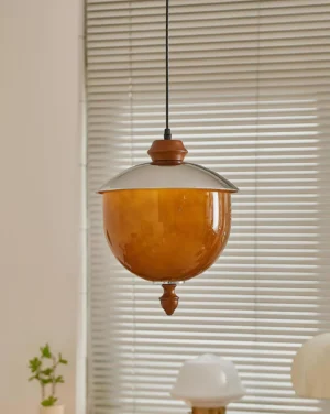 Tavira amber glass pendant lamp with brushed metal upper cap and wood accents hanging indoors