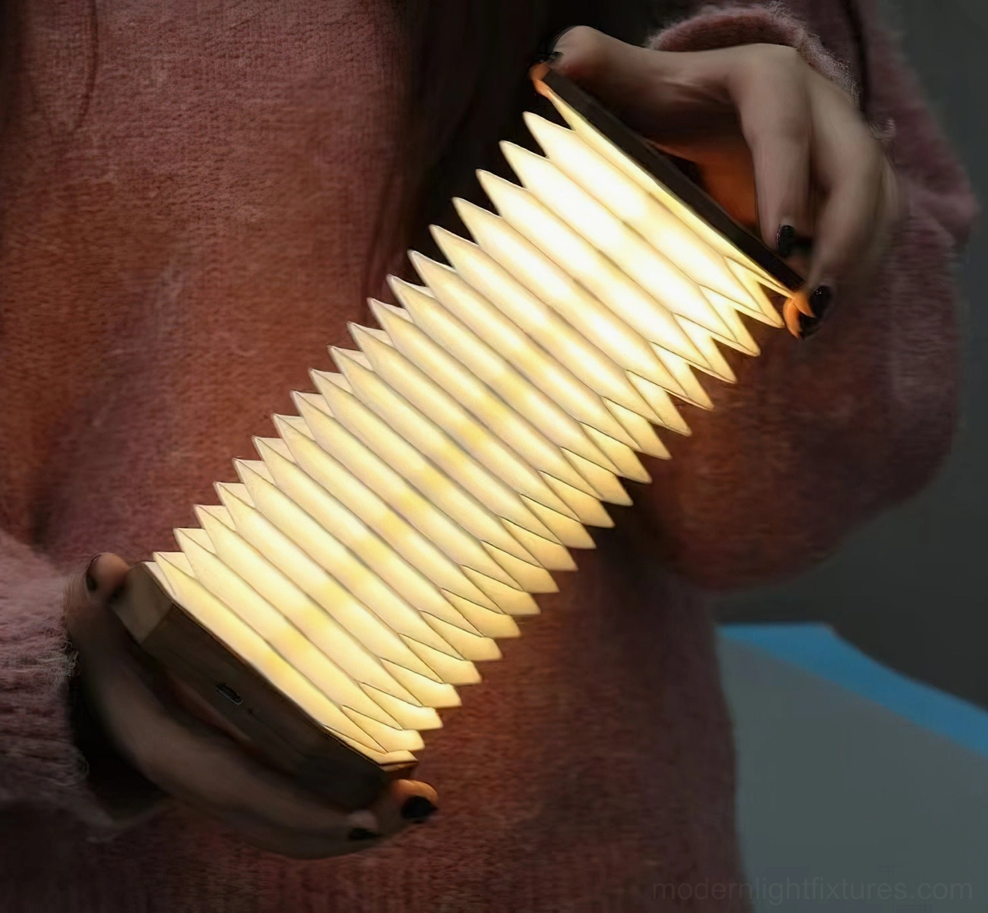 Hand stretching expanding Tawa Fold accordion pleated shade showing adjustable height feature