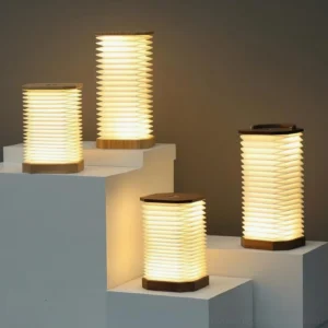 Multiple Tawa Fold accordion table lamps displayed at different heights showing warm ambient lighting