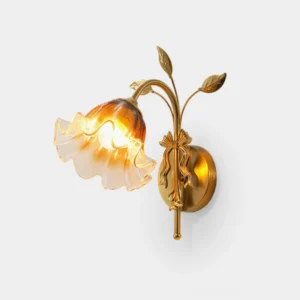 Tender Glimmer brass wall sconce with leaf motifs and hand-shaped amber glass shade, front close-up view