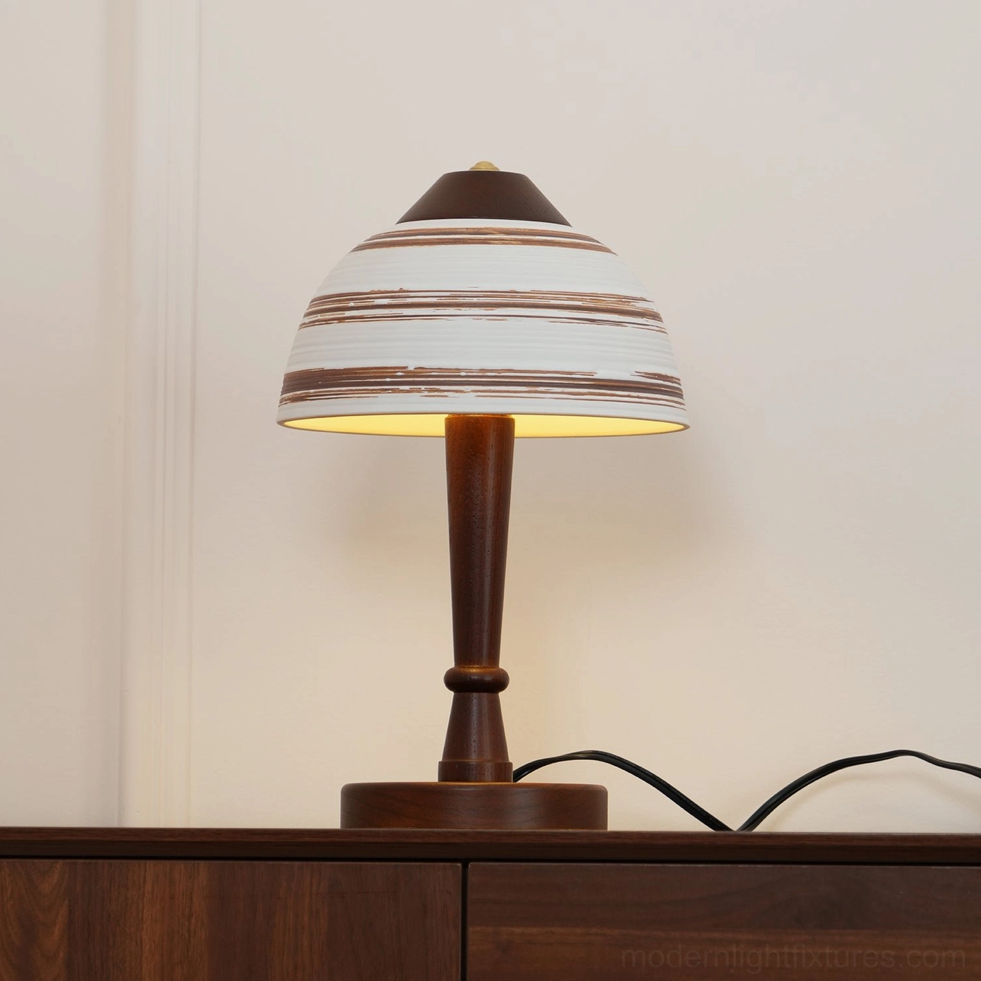 Tera table lamp illuminated creating ambient lighting and shadow effects in room setting