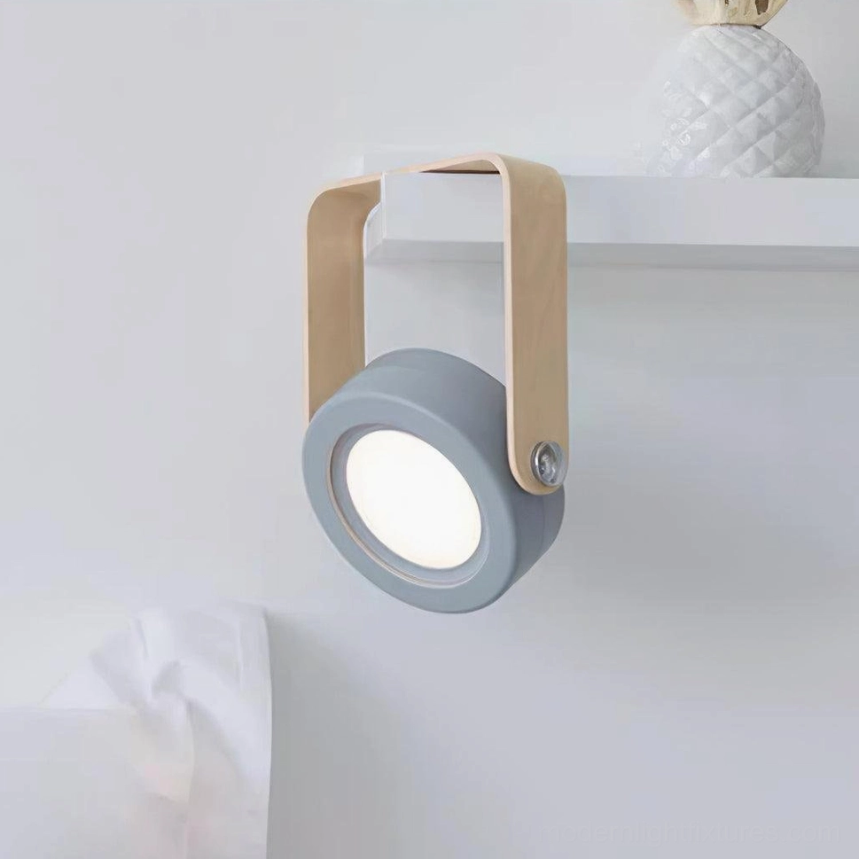 Terna Portable Table Lamp - Front side view with gray-blue lamp head and rotatable wood frame displayed on indoor shelf