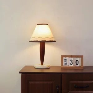 Terracotta table lamp with marble base on wooden sideboard creating warm ambient light in living room