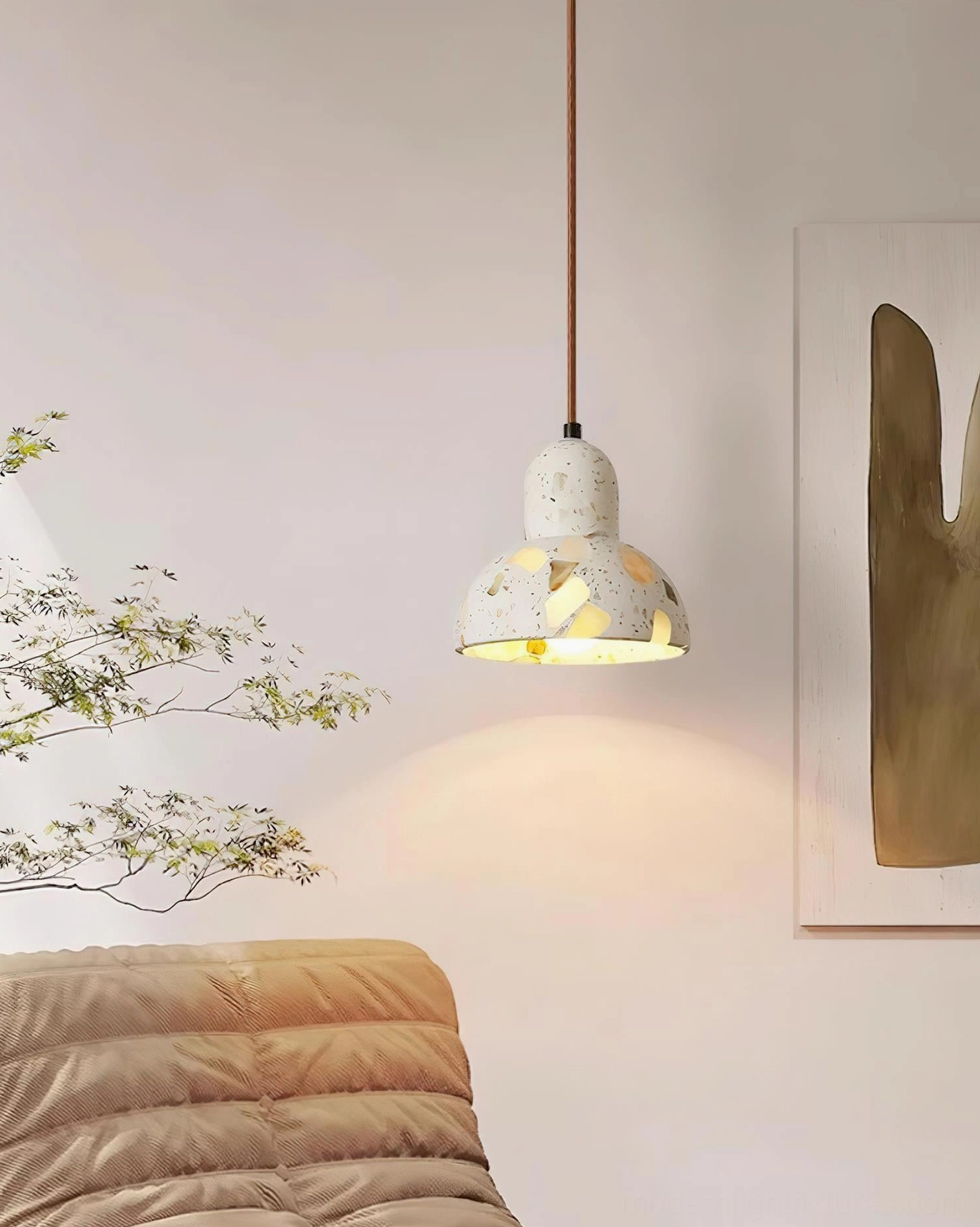 Terrazzo pendant light illuminated showing warm glow through composite stone shade